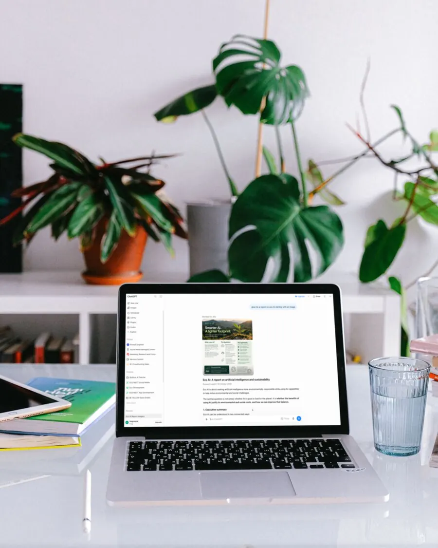 Laptop showing an AI chat assistant on a desk surrounded by green plants